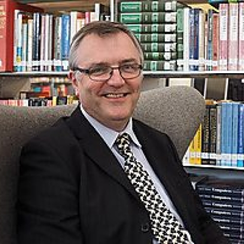 A photograph of librarian, Timothy, smiling at the camera