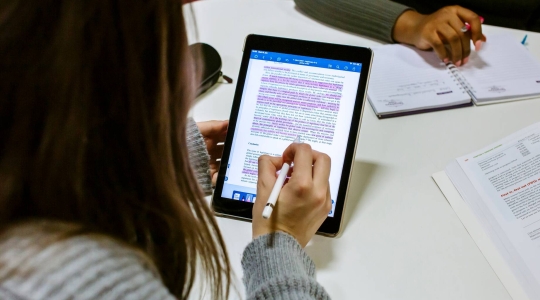 Woman highlighting and annotating an ebook on a tablet computer