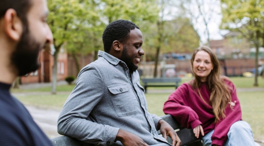 Students sat chatting on a bench in Ravelin Park