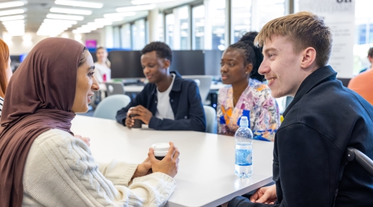 Students chatting around a table in the Library Café