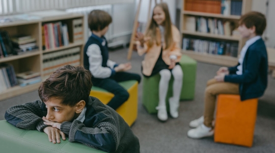 Children sat in a Library - from Pexels - https://www.pexels.com/photo/boy-in-gray-sweater-sitting-on-green-leather-couch-7929418/