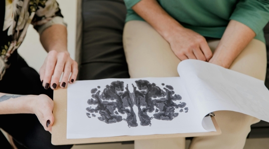 Rorschach inkblot - from Pexels, https://www.pexels.com/photo/a-person-holding-a-clipboard-with-artwork-9064394/