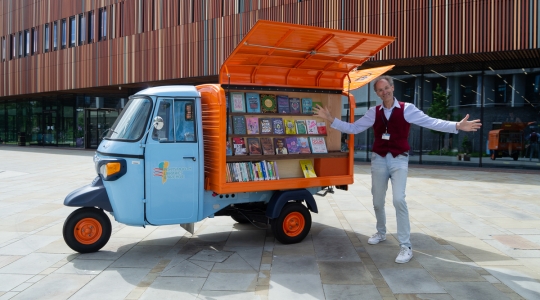 Librarian from the public library presenting the tuk-tuk full of books