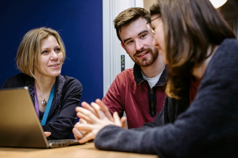 Librarian with laptop and students