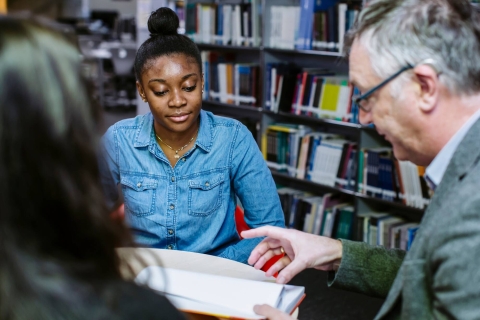 Faculty Librarian with students in the Library