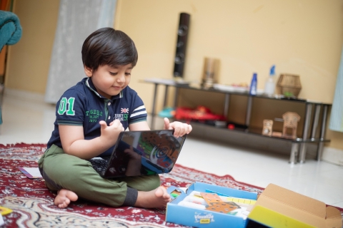 Young boy sat using a tablet computer