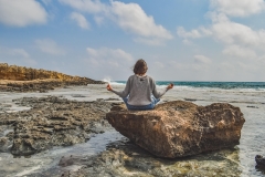 Woman meditating on the seashore