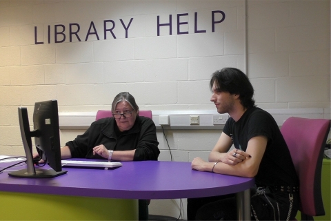 Librarian helping someone at the Library Help Desk