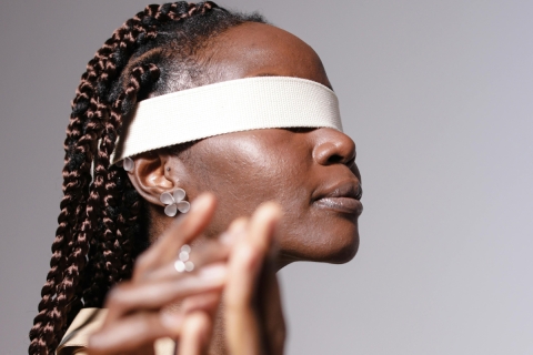 Woman wearing a blindfold, reaching out to touch another's hand - from Pexels, https://www.pexels.com/photo/woman-wearing-brown-coat-blindfolded-10143610/
