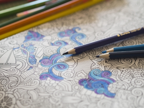 Semi-abstract swirling printed pattern partially coloured in using coloured pencils