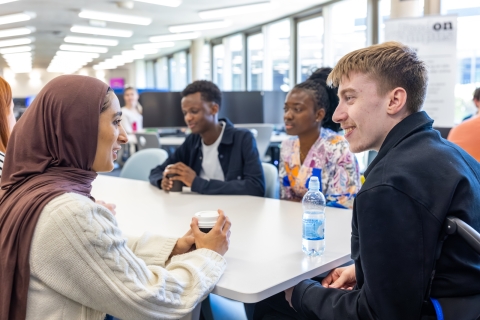 Students chatting around a table in the Library Café