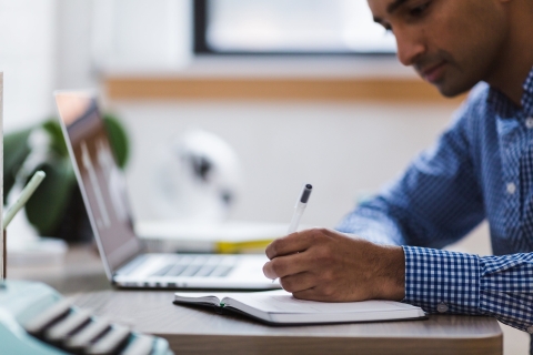 Man making notes from his laptop