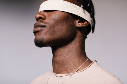 Black man stood wearing a blindfold