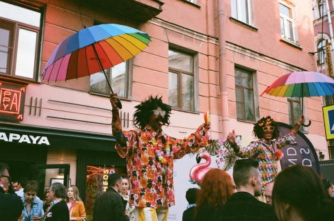 Street performers with rainbow umbrellas - from Pexels, https://www.pexels.com/photo/two-men-performs-on-stage-while-holding-rainbow-colored-umbrellas-2422474/