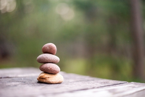Stacked pebbles on a wooden table.   From Pexels - https://www.pexels.com/photo/four-rock-formation-668353/