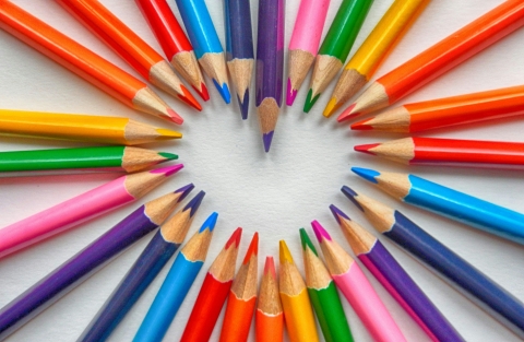 Coloured pencils arranged in a heart shape