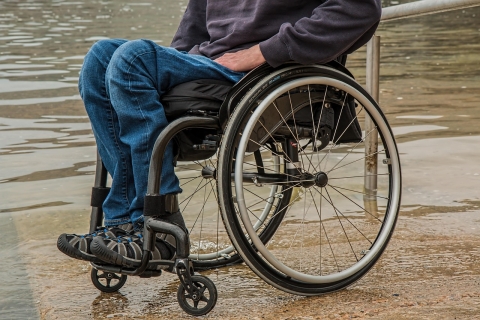 Cropped photograph of a man in a wheelchair with atrophied legs