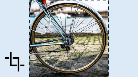 A photograph of a bicycle, with a dashed border indicating a crop boundary. The crop cuts into the image on all sides, removing parts of the original composition.