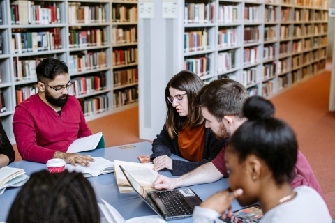 5 people sitting in a group making notes