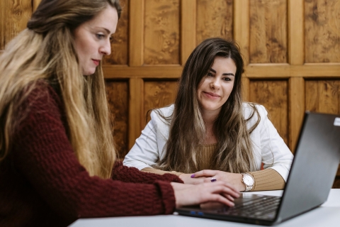 A student and a member of staff looking at a laptop screen together during a one-to-one session.