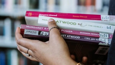 student carrying stack of books
